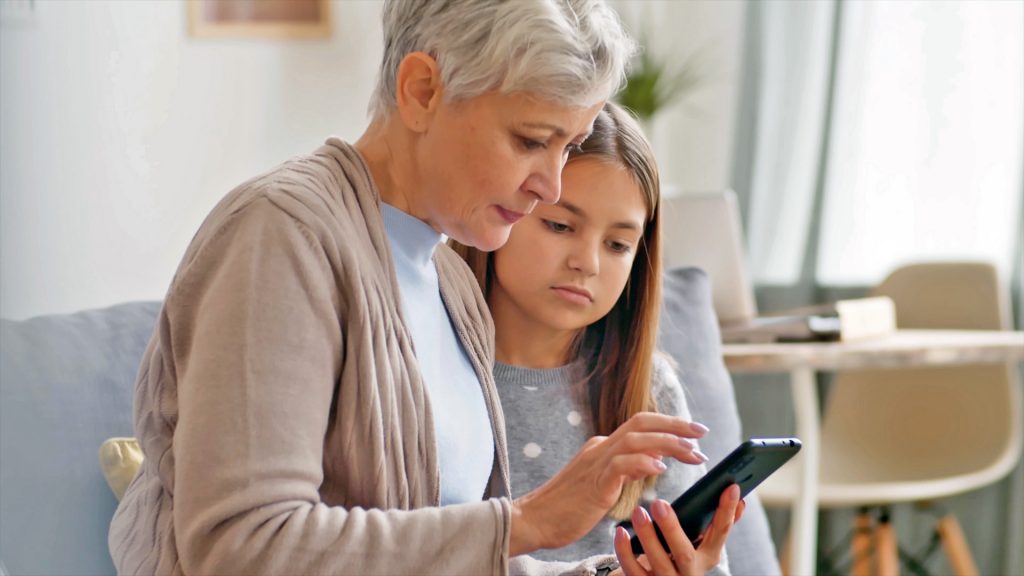 Elderly woman with kid using a smartphone