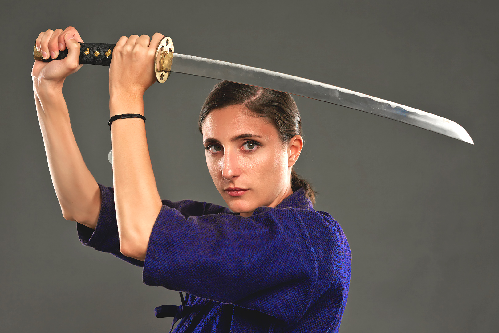 Focused woman holding a samurai sword