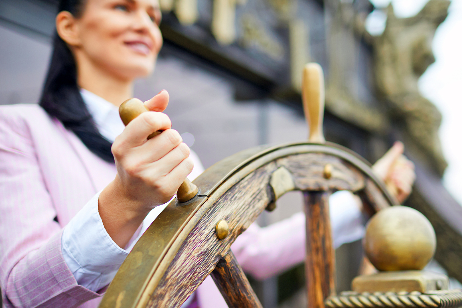 Business woman in a ship holding a rudder