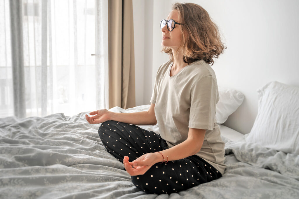 Woman meditating in her bed