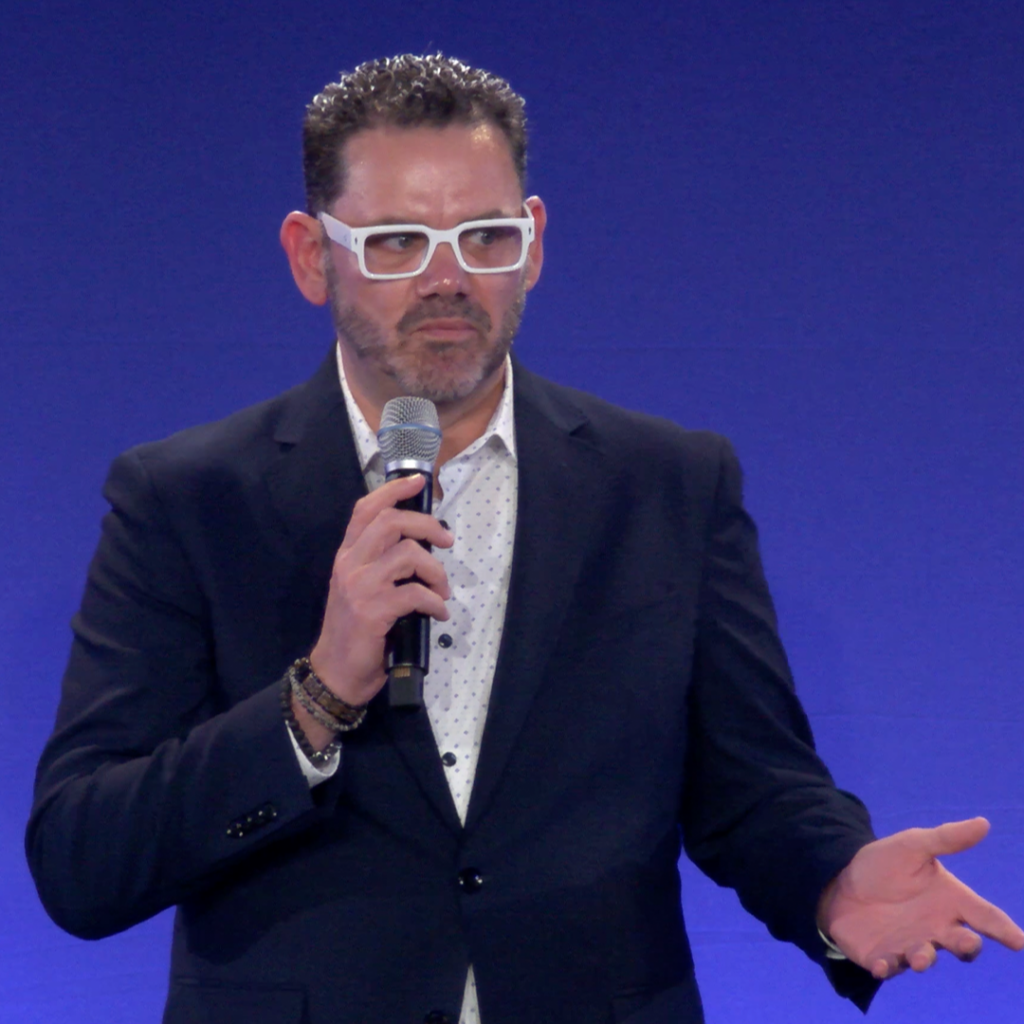 Chris Dyer speaking on stage about business culture and leadership